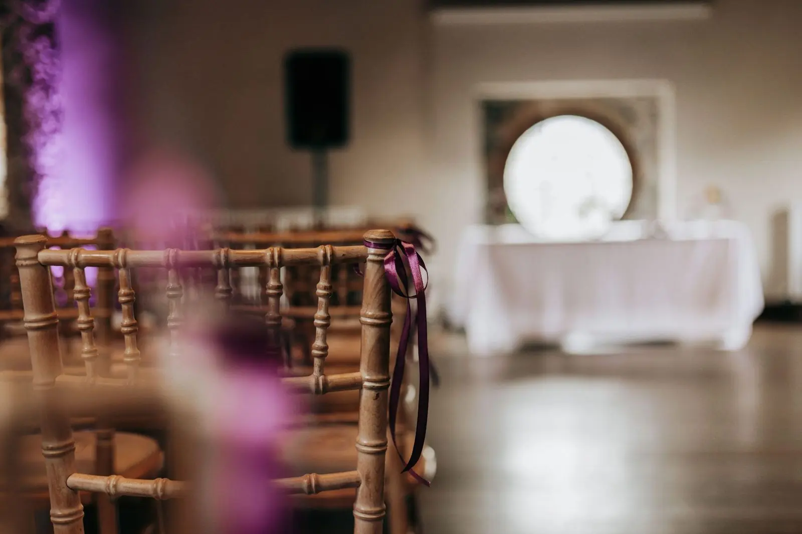Wooden chairs with plum ribbons in the barn ceremony room