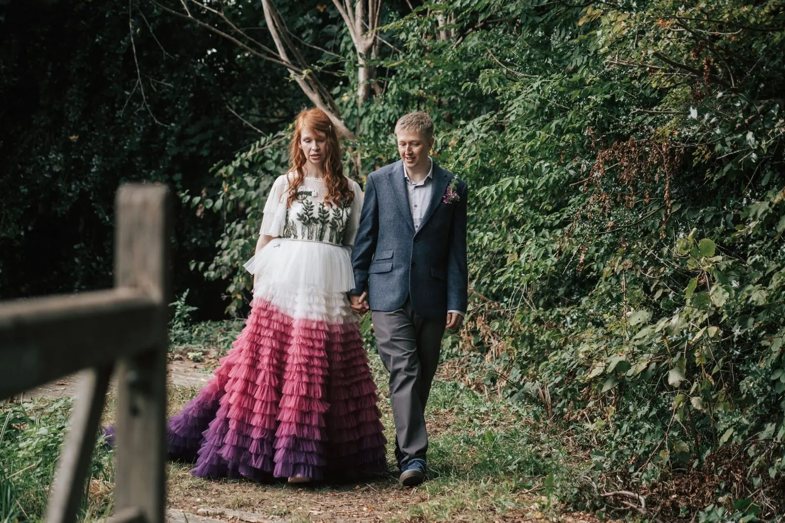 Couple walking hand in hand along a path through the garden