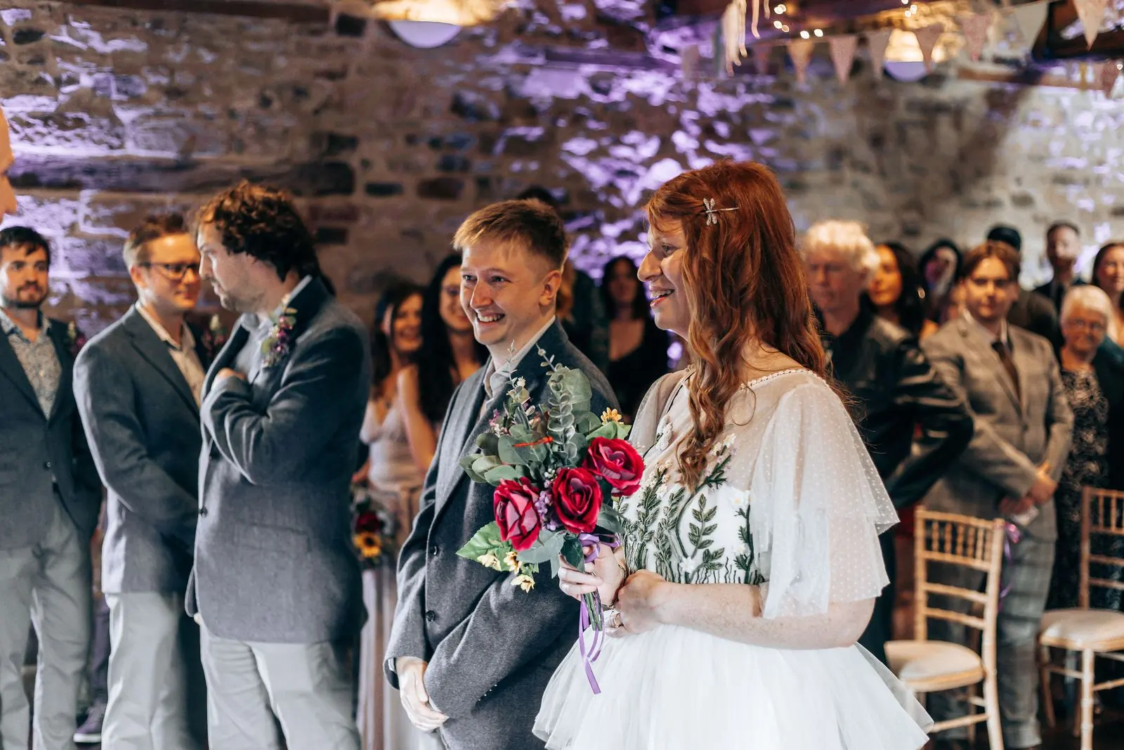 Couple smiling at each other at the top of the aisle